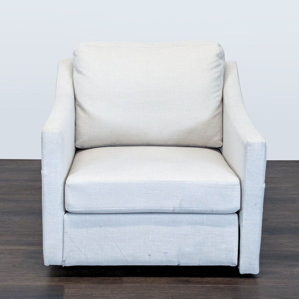 Modern lounge chair with neutral upholstery, soft cushions, and sloped arms for stylish, comfortable seating.