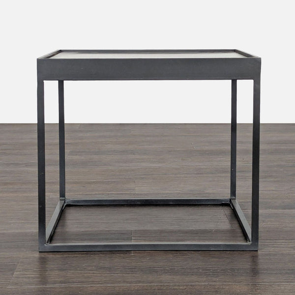 1. Minimalist square metal side table with thin black frame, shown on a dark wooden floor, straight-on view.  