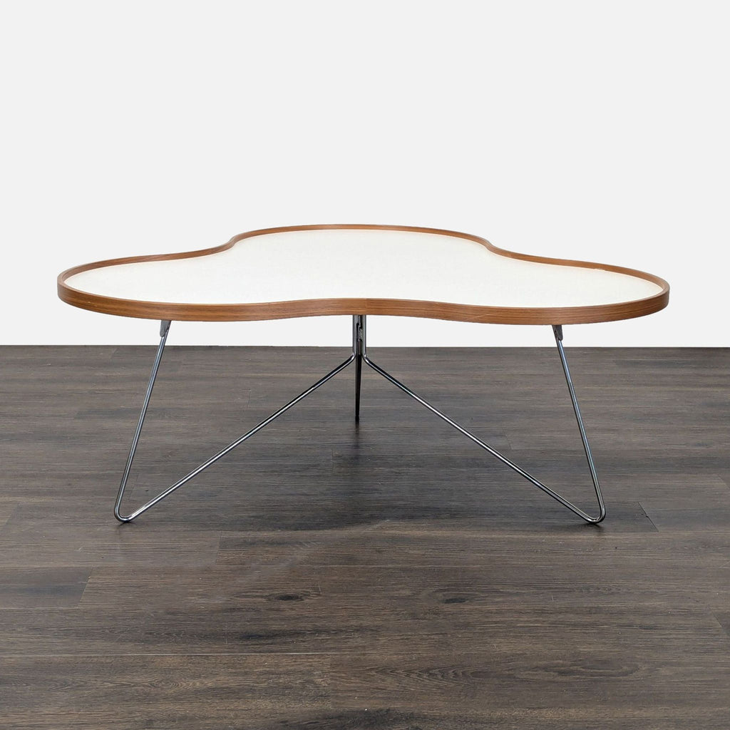 Organic-shaped Swedese coffee table by Christine Schwarzer, with white laminate top, wood trim, and chrome stem legs.