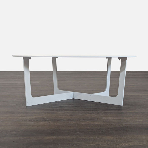 White Insula Coffee Table by Jorgensen, aluminum construction with angled legs, shown on a dark wood floor.
