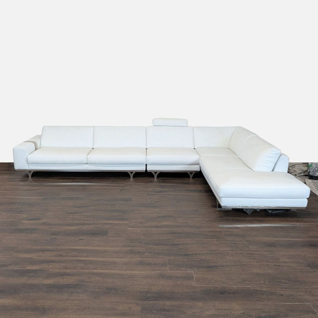 1. White Roche Bobois sectional sofa with Italian leather, metal legs, and chaise lounge on dark wood floor.