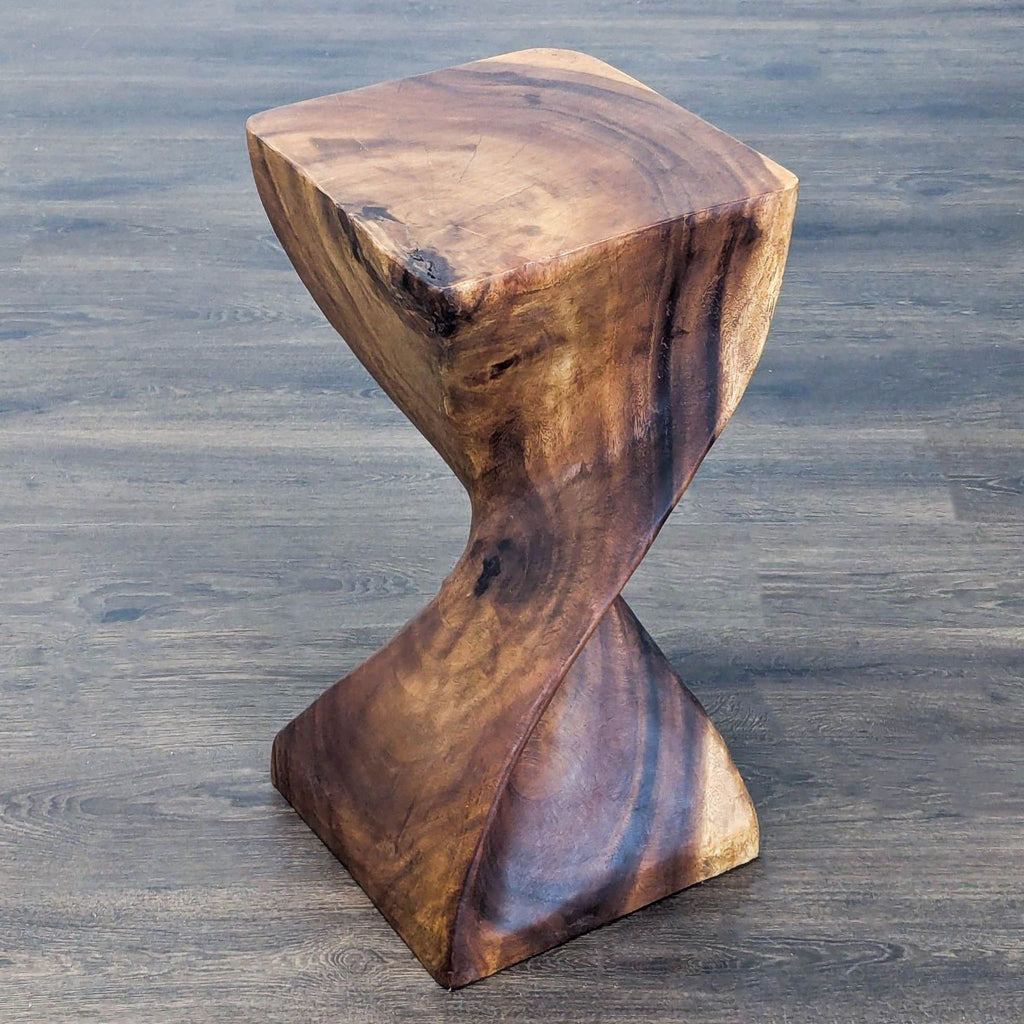 1. Sculpted wood end table with a twisted, modern design and natural grain, placed on a hardwood floor.