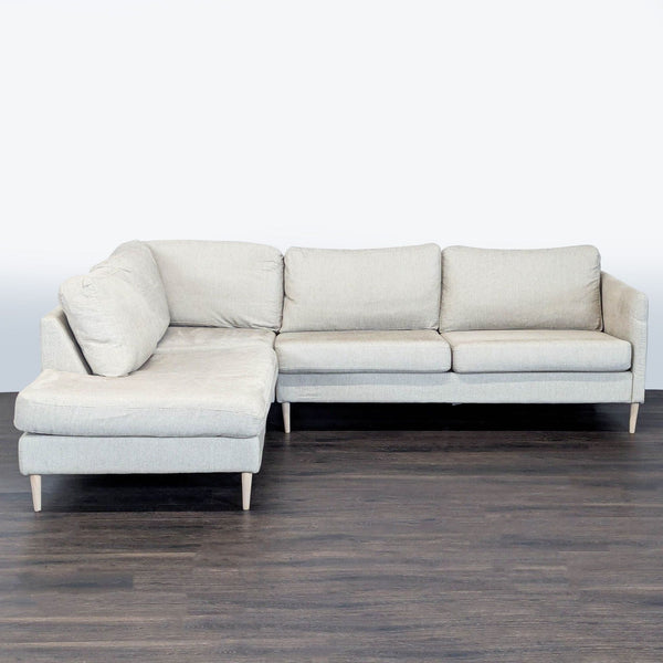 Modern BoConcept sectional in cream fabric with chaise, clean lines, and wooden legs—comfortable and stylish seating.