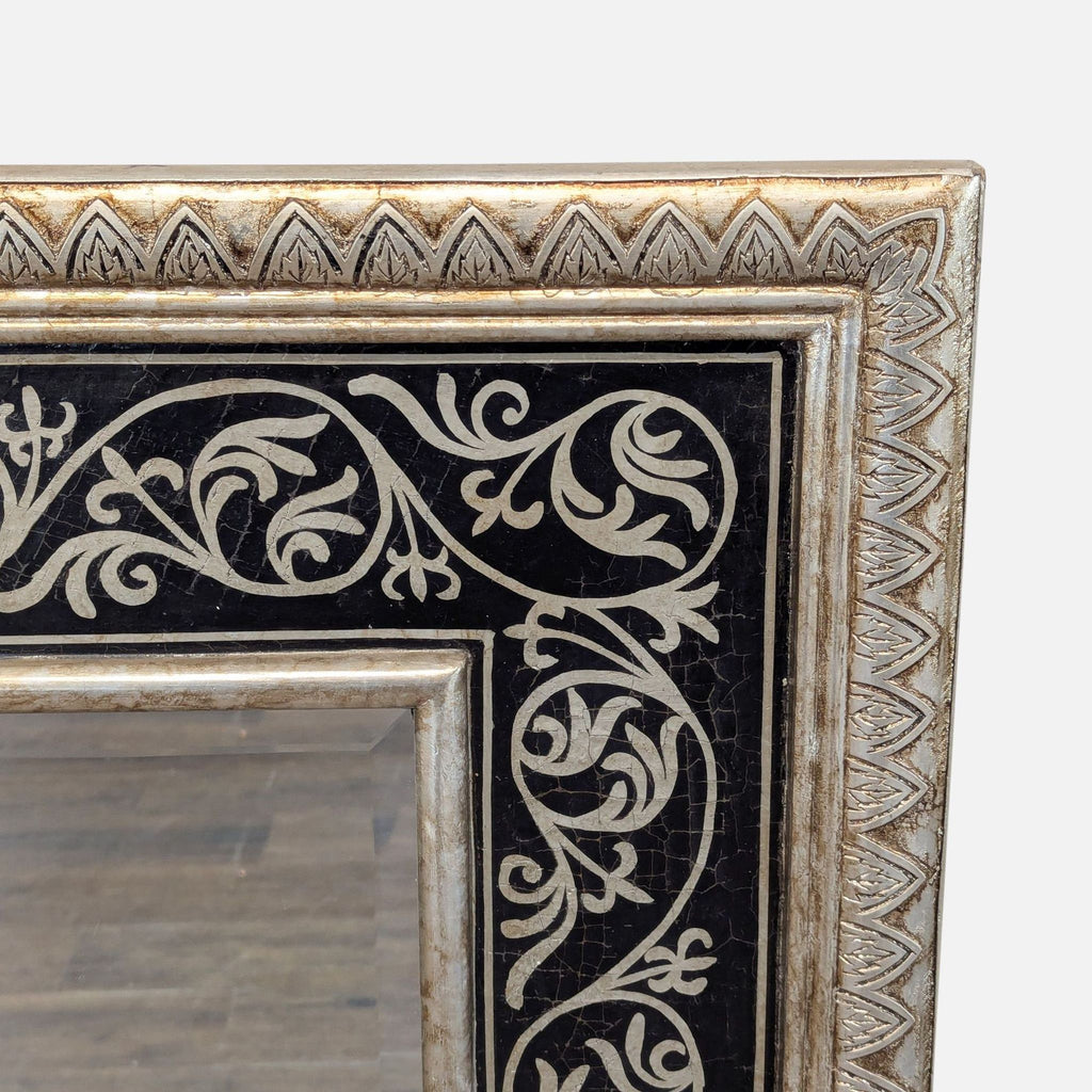 3. Close-up of the decorative mirror frame, showing detailed silver vine patterns on a black background.