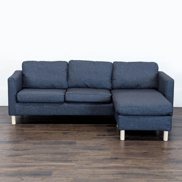 Dark blue Ikea sectional sofa with right-side chaise, three cushions, and light wood legs for modern living rooms.