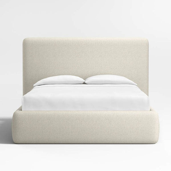1. Modern cream upholstered bed frame by Crate and Barrel, shown with white bedding, front view.  