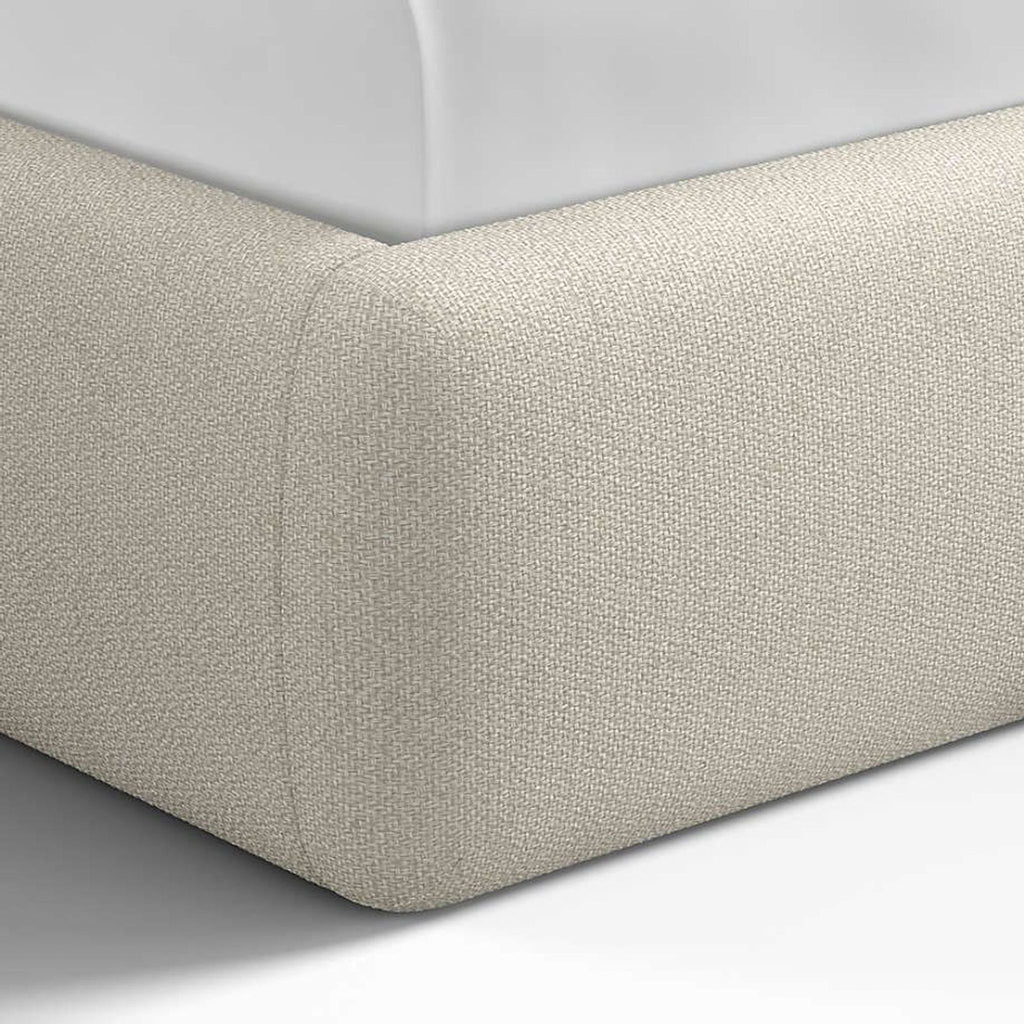 3. Detailed corner view of Crate and Barrel cream upholstered bed frame highlighting fabric texture.