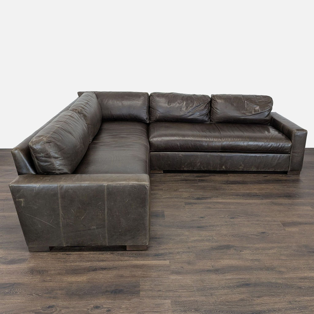 Restoration Hardware brown leather sectional with deep seats and modern design, showing minor wear.  