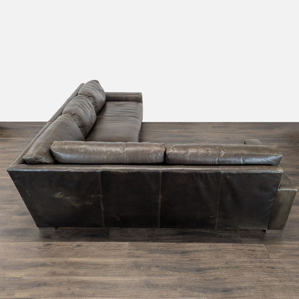 2. Side view of a modern Restoration Hardware brown leather sectional, sturdy with visible signs of normal use.  