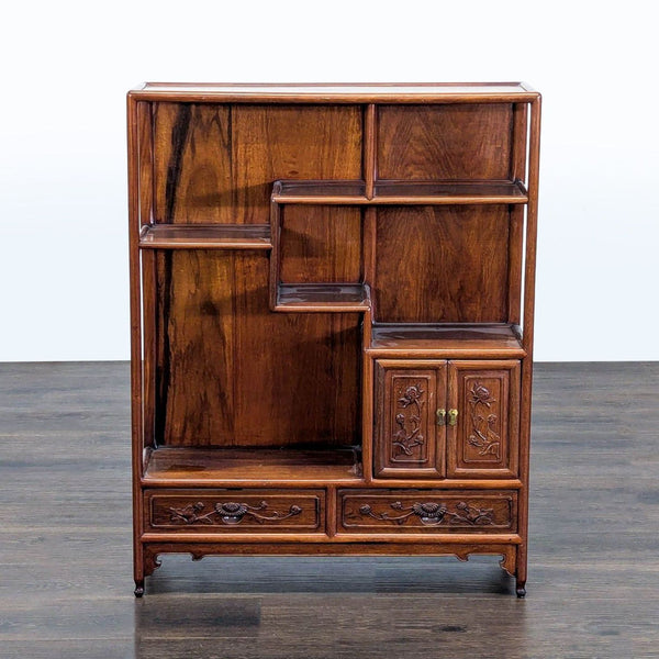 Stepped wooden bookshelf with open shelves, two carved drawers, and a cabinet, ideal for storage and display.