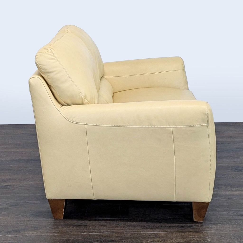 Natuzzi leather loveseat featuring sturdy wooden legs and a sleek, contemporary design for two people.  