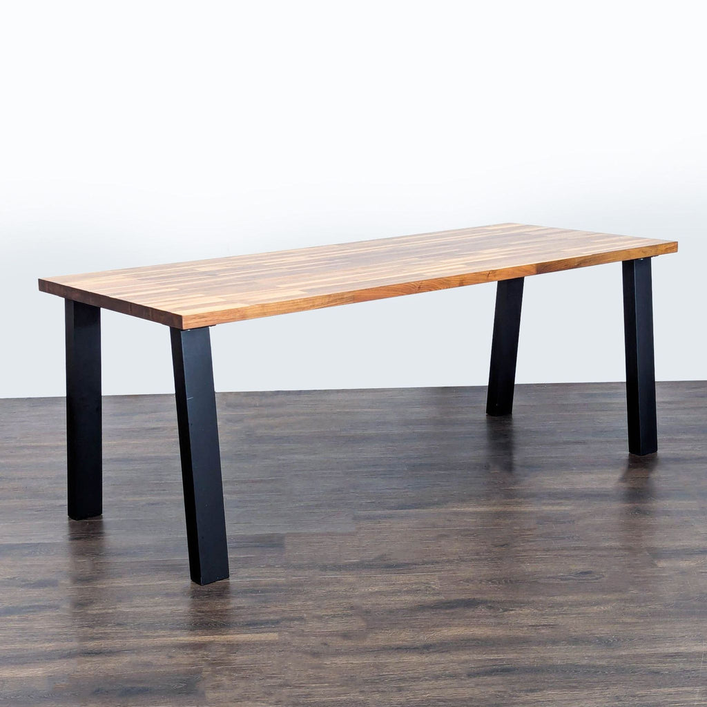 3. Angled view of an Ikea dining table featuring a walnut veneer top and sturdy black legs.