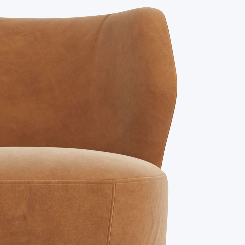 Arteriors Home lounge chair in tan faux leather, rounded silhouette, and sturdy metallic swivel base.