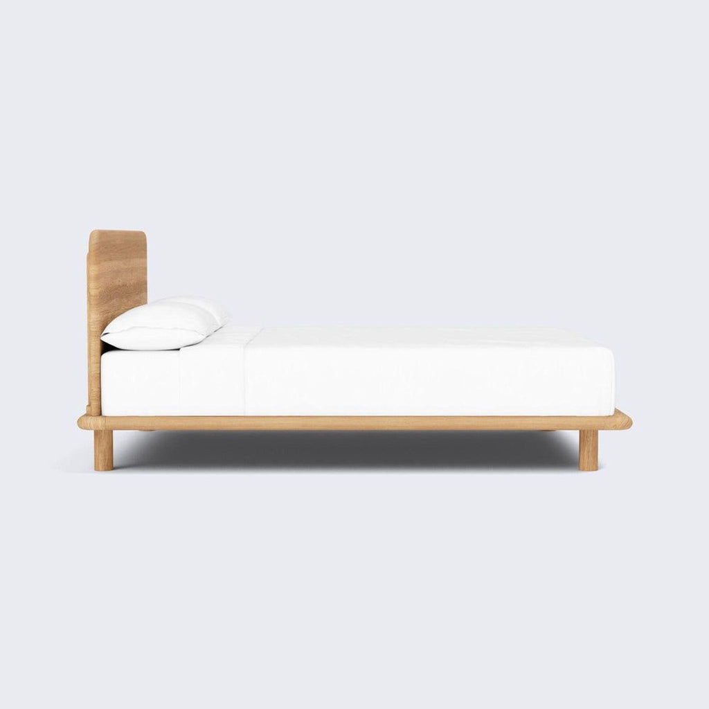 Low-profile platform bed frame in sturdy oak with smooth edges, perfect for a contemporary and calming sleep space.  