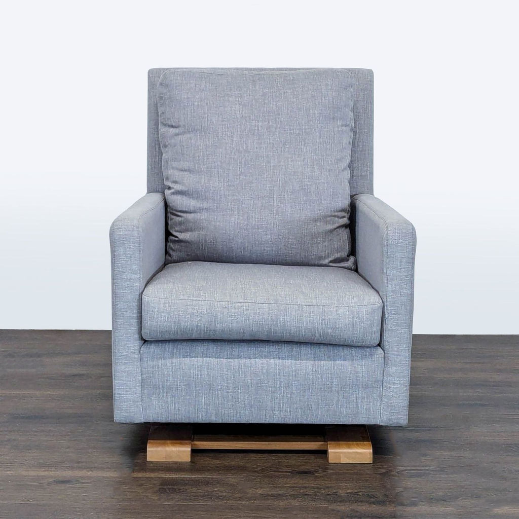 Monte lounge chair in soft gray fabric with cushioned seat, wooden glider base, and modern minimalist design.