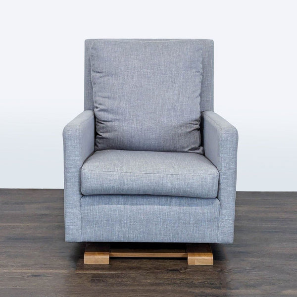 Monte lounge chair in soft gray fabric with cushioned seat, wooden glider base, and modern minimalist design.