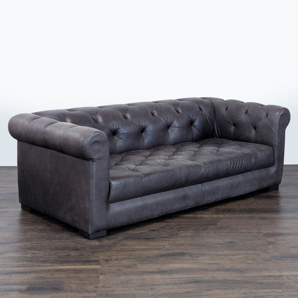 Tufted leather Restoration Hardware couch with rolled arms and spacious seating, blending durability and style.