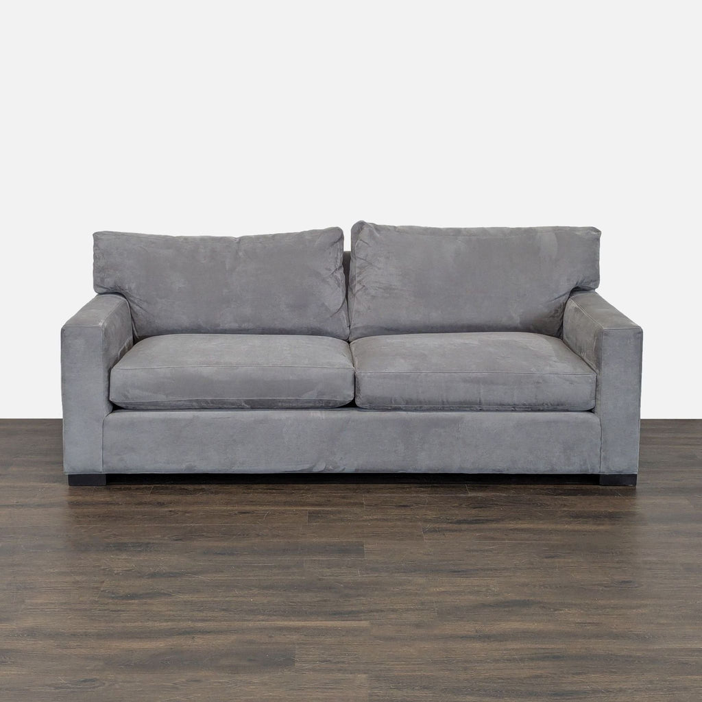 Crate and Barrel gray 3-seat sofa with wide arms, clean lines, and plush cushions in a modern living room.