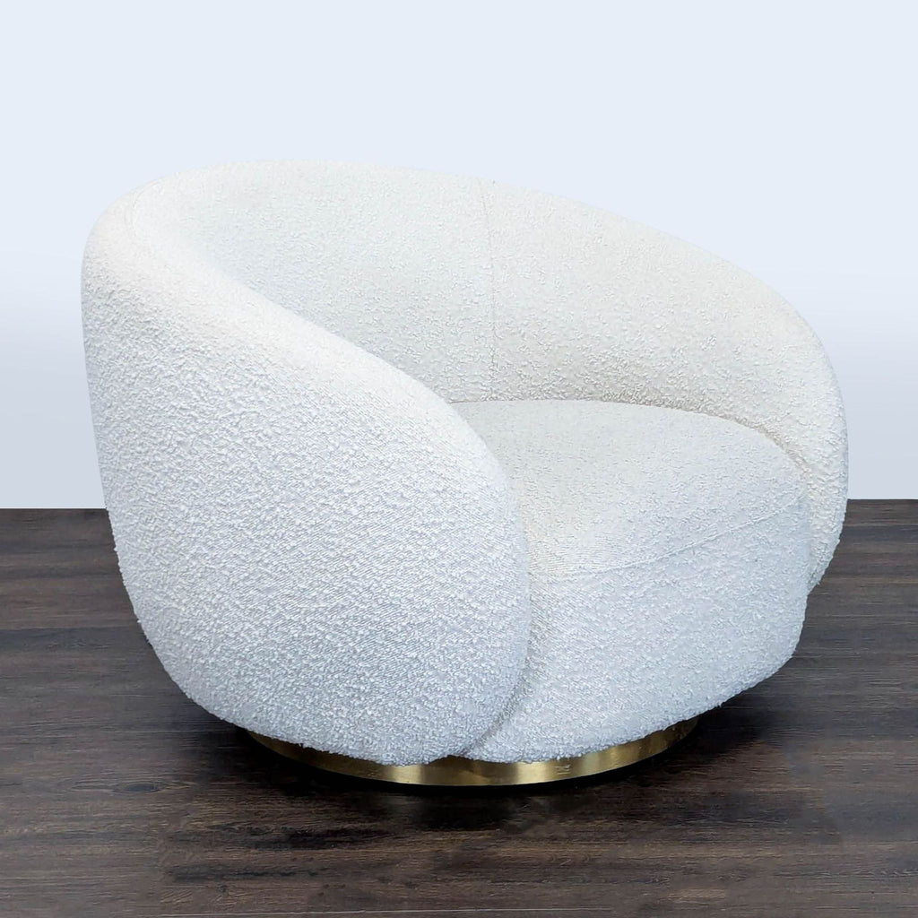 3. Angled view of an Eichholtz lounge chair in white bouclé with a spacious seat and sturdy brass base.