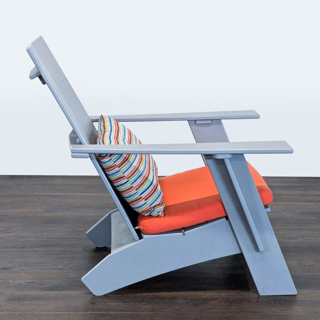 Room & Board Adirondack-style chair featuring a sturdy gray frame, orange seat pad, and colorful striped pillow.