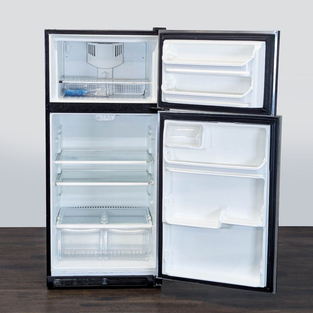 Frigidaire refrigerator with two crisper drawers, glass shelves, and organized freezer section in stainless steel.