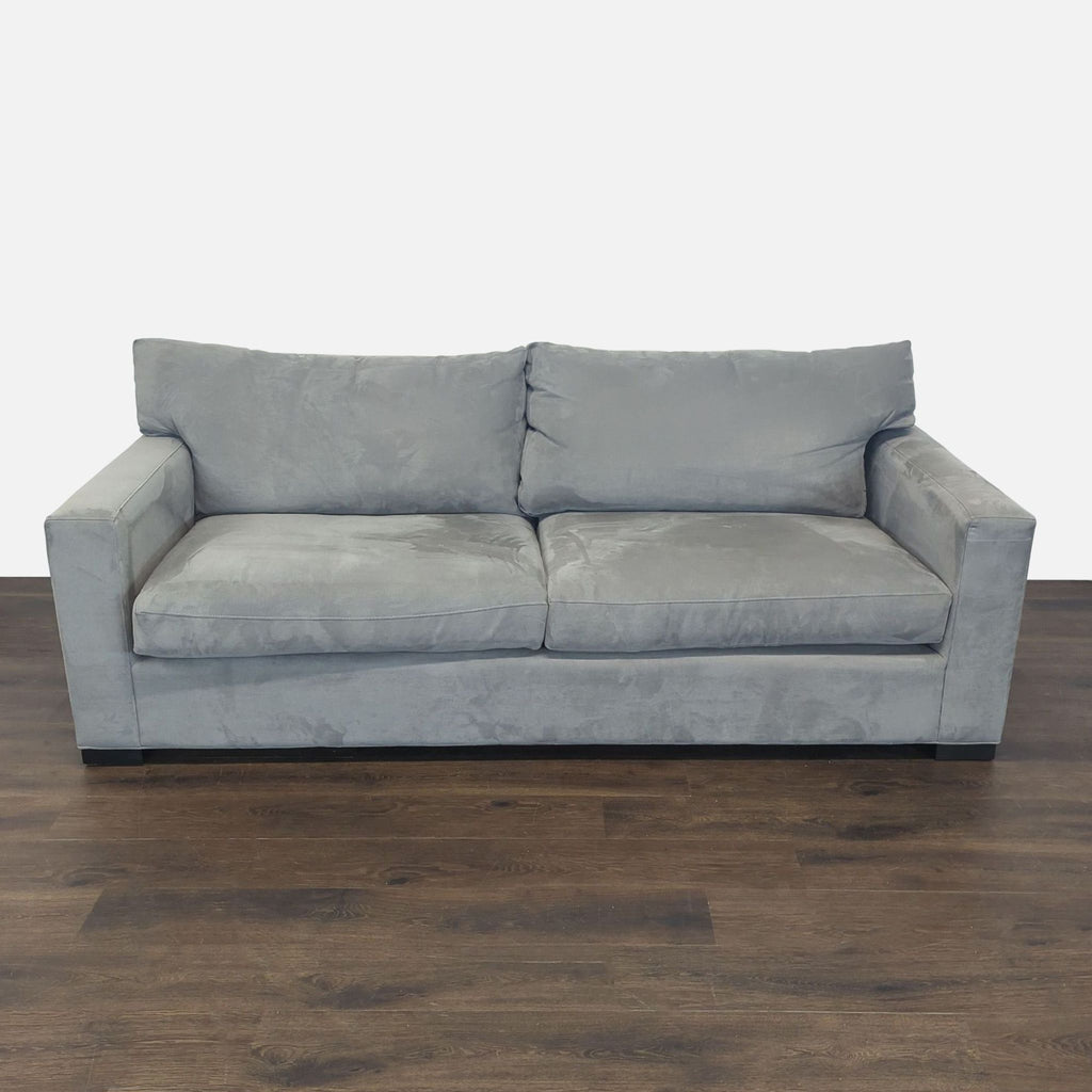 Crate and Barrel gray 3-seat sofa with modern lines and plush cushions, shown in a living room setting.