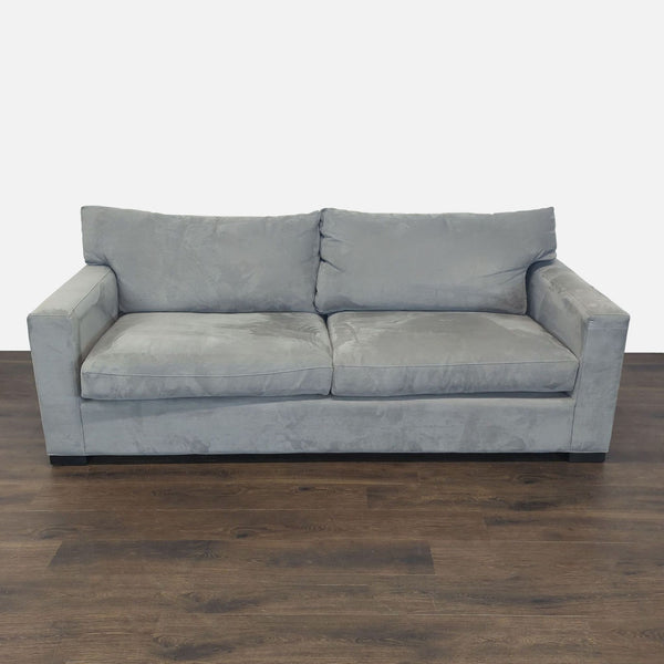 Crate and Barrel gray 3-seat sofa with modern lines and plush cushions, shown in a living room setting.