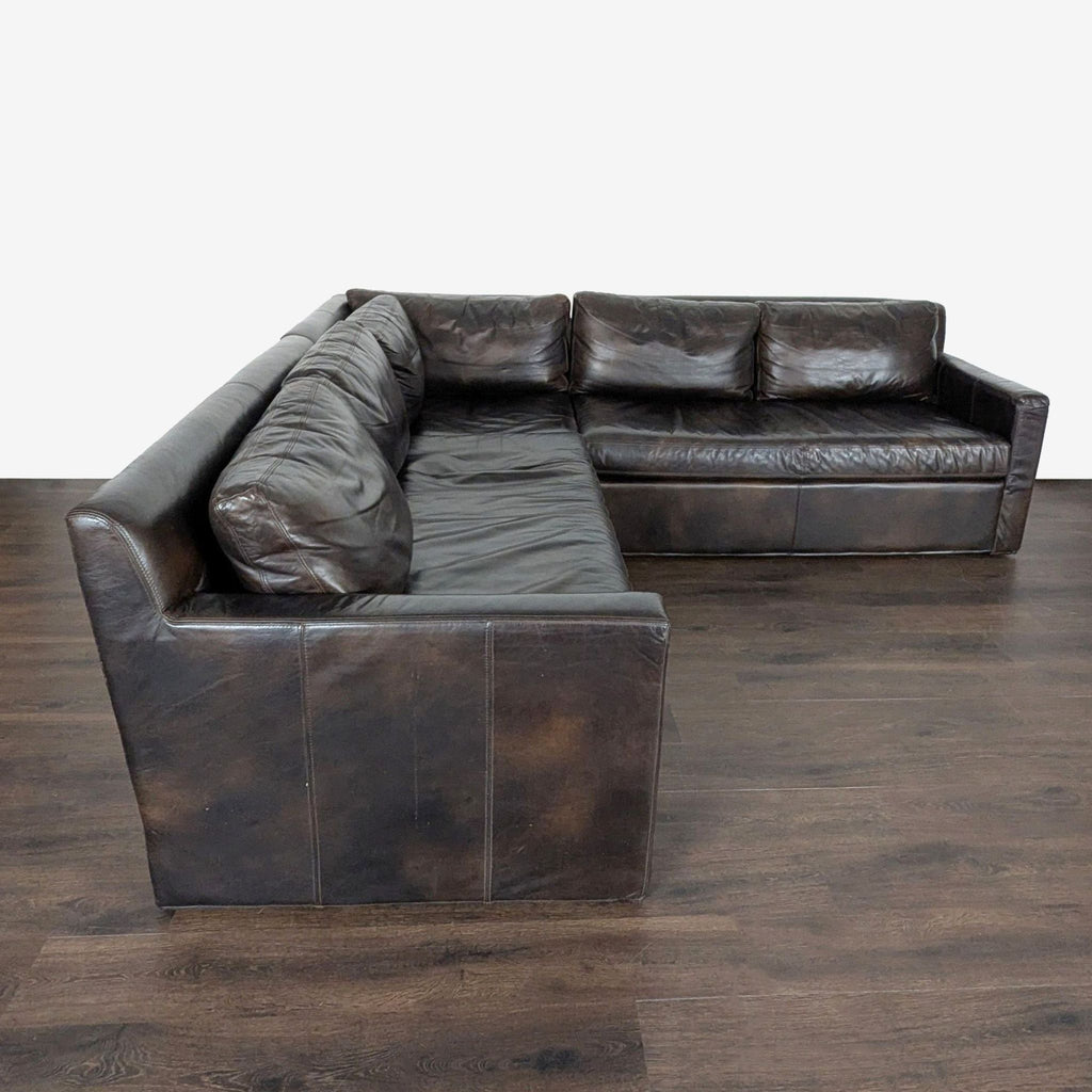 Dark brown leather sectional sofa by Restoration Hardware, featuring a sturdy build and generous seating area.