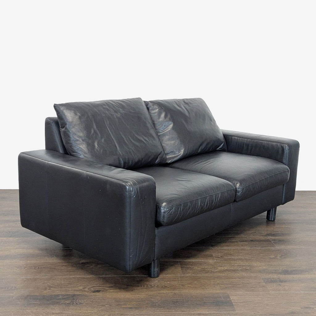Modern black Ekornes Stressless loveseat with soft seats and back, combining durability and comfort for any room.