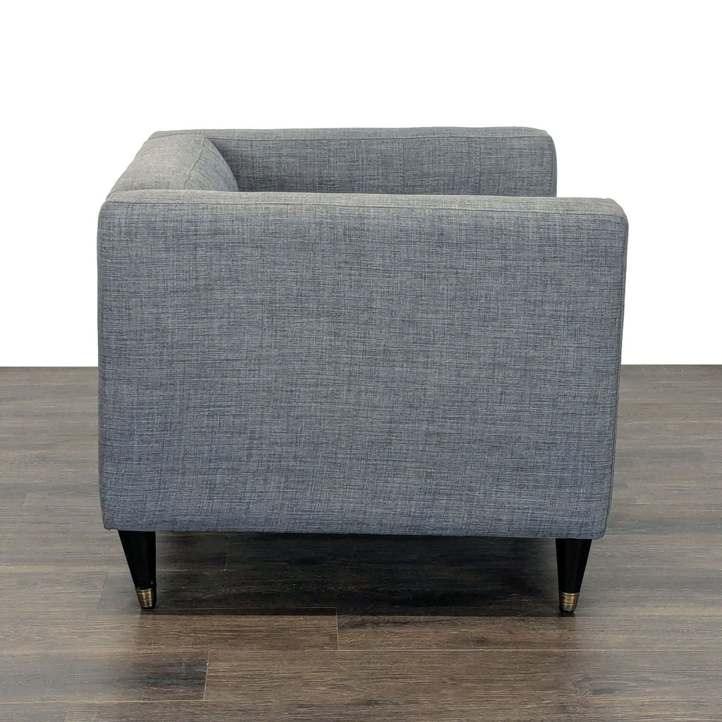 Tufted deep-seat gray lounge chair featuring sleek black and gold legs, offering comfort and a contemporary look.