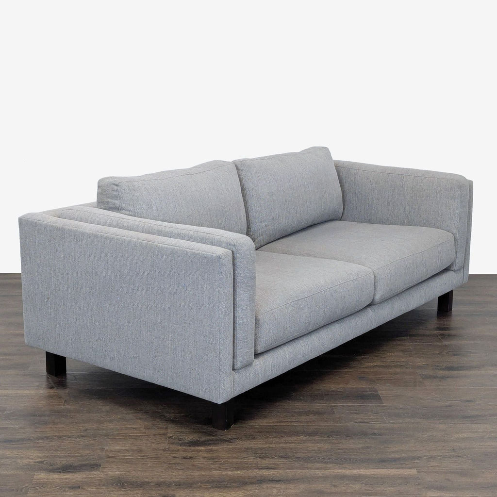 Gray upholstered loveseat by Room and Board, featuring sleek design and plush cushions for comfort and durability.  