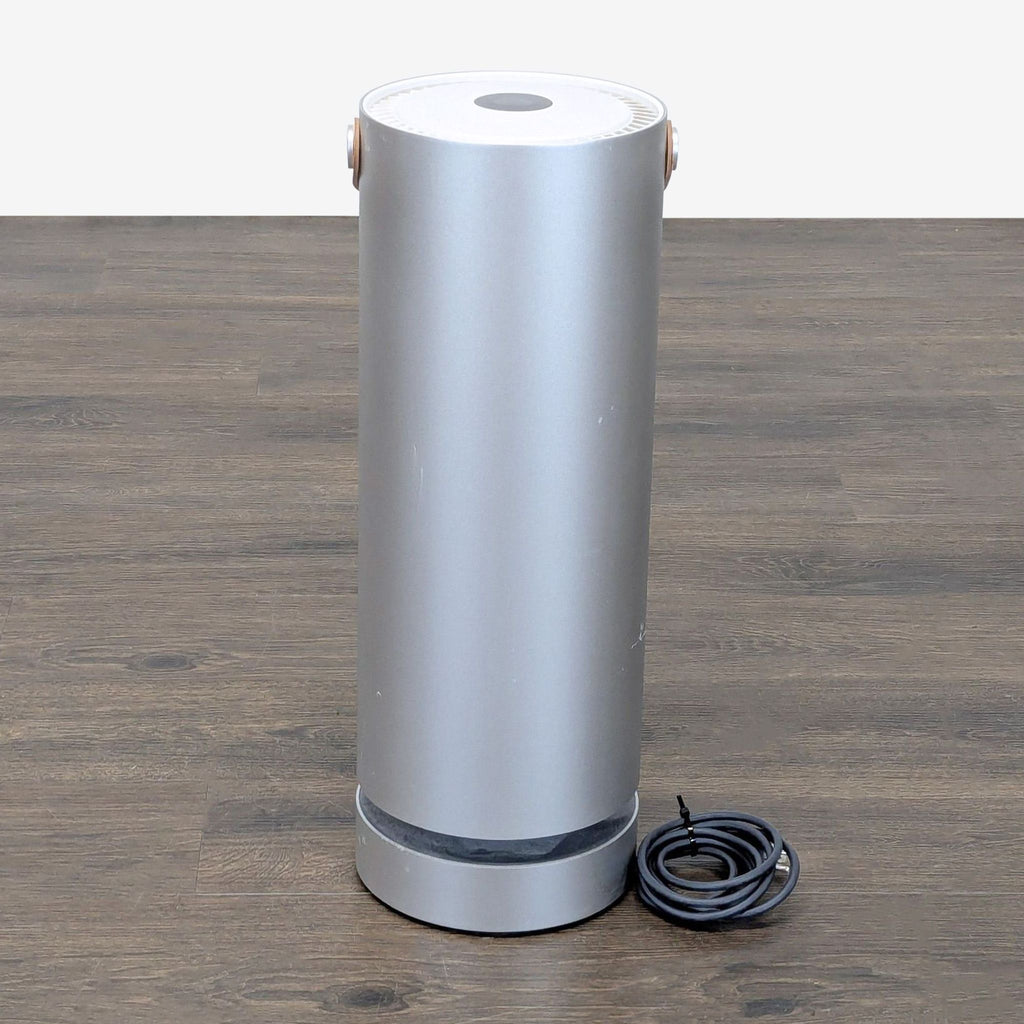 Modern Molekule air purifier, power cord, and compatible replacement filters arranged together on a surface.  