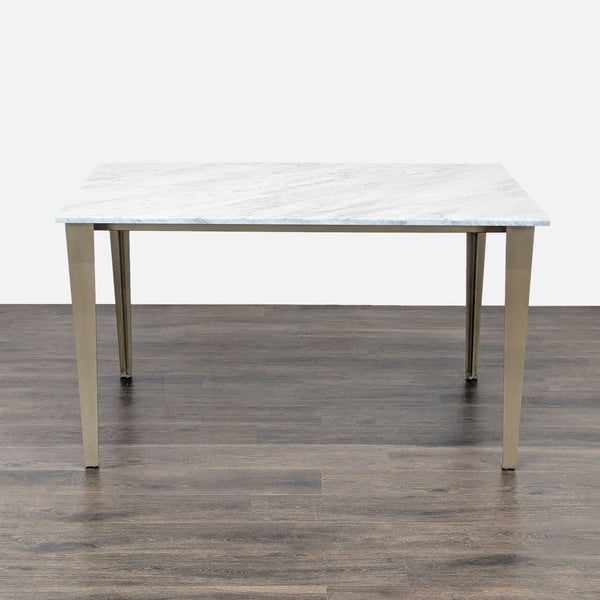CB2 dining table with a polished white Carrara marble top and sculptural antiqued brass iron legs.