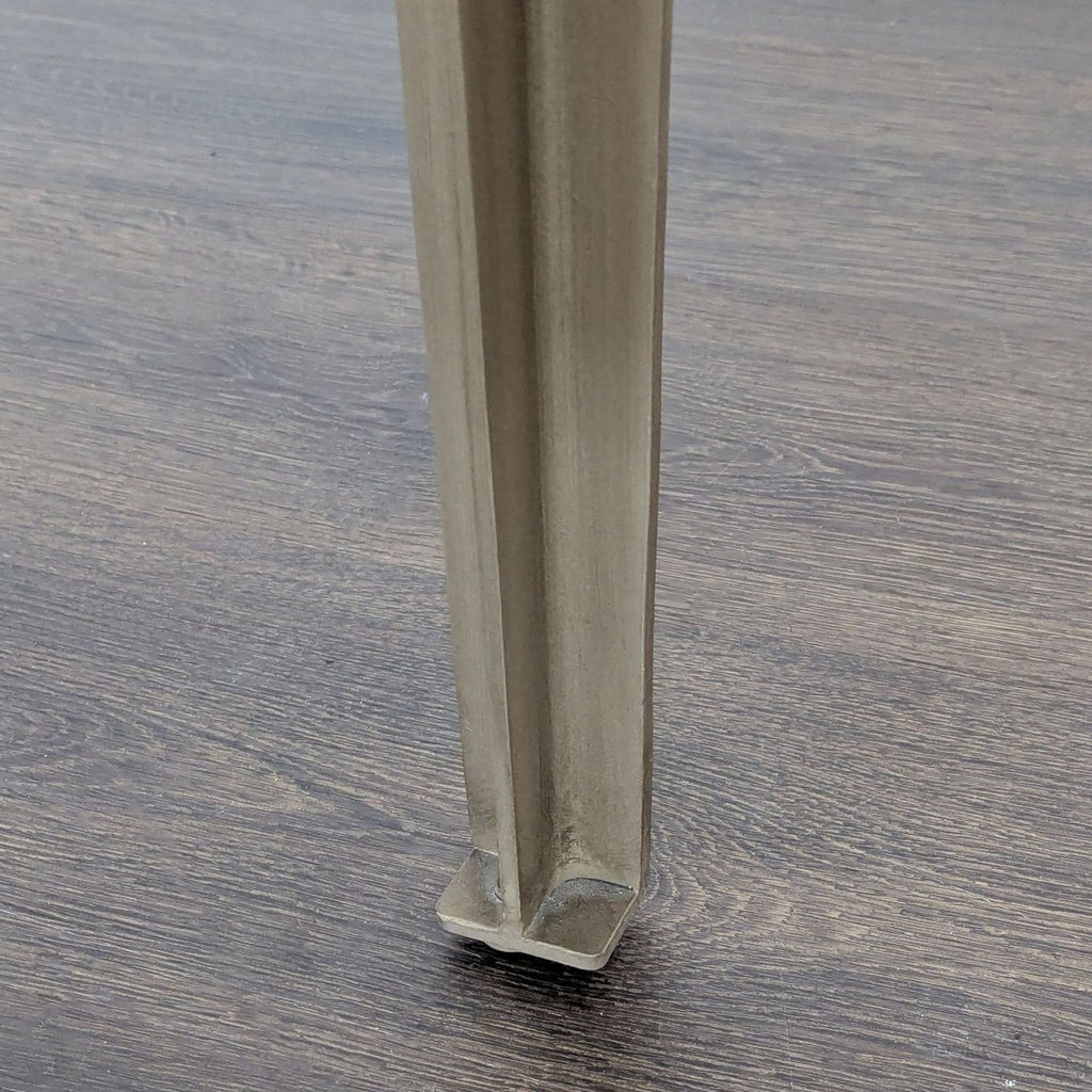 Elegant CB2 table with white marble surface and bent iron legs in antique brass, perfect for contemporary dining spaces.