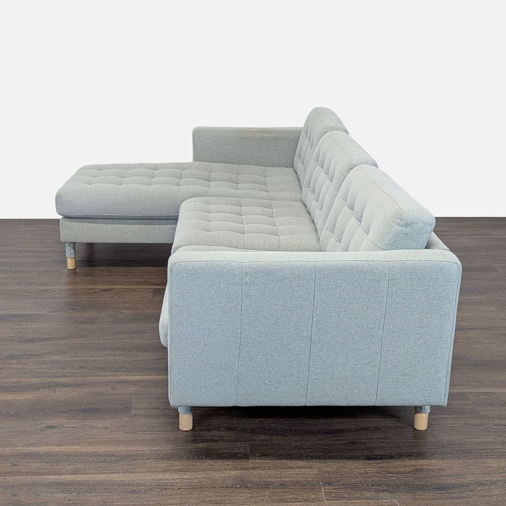 Modern Ikea sectional in light gray fabric with spacious chaise, clean lines, and sturdy wood legs.