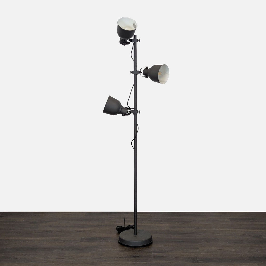 Triple-head Ikea floor lamp with a sturdy base and adjustable lights for customizable room lighting.