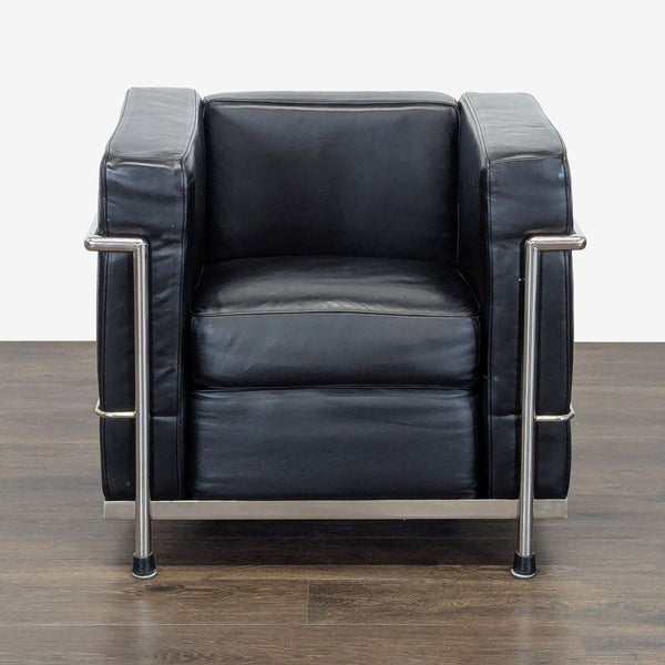 Modern black leather lounge chair with polished metal frame, ideal for stylish living rooms by Design Within Reach.