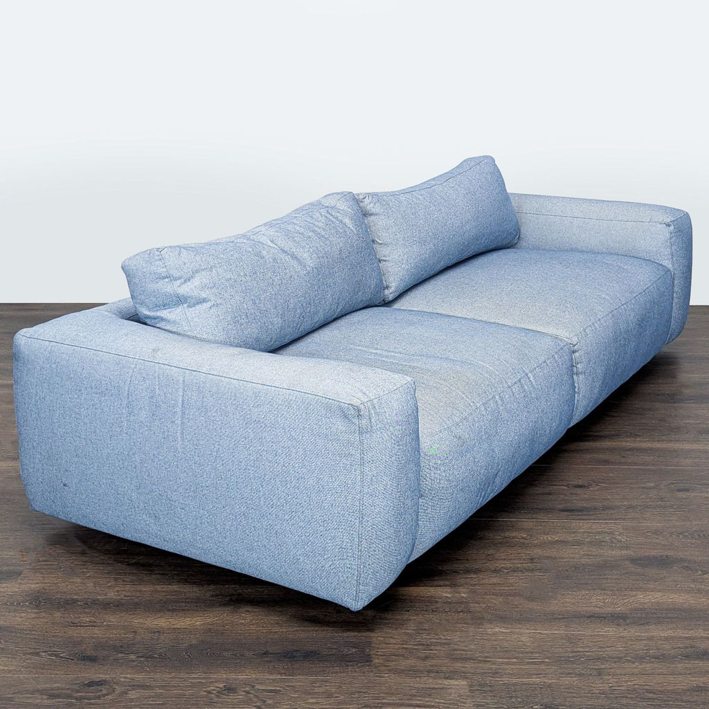Contemporary 3-seater sofa by Four Hands in soft blue, designed with spacious, cushioned seats and clean lines.
