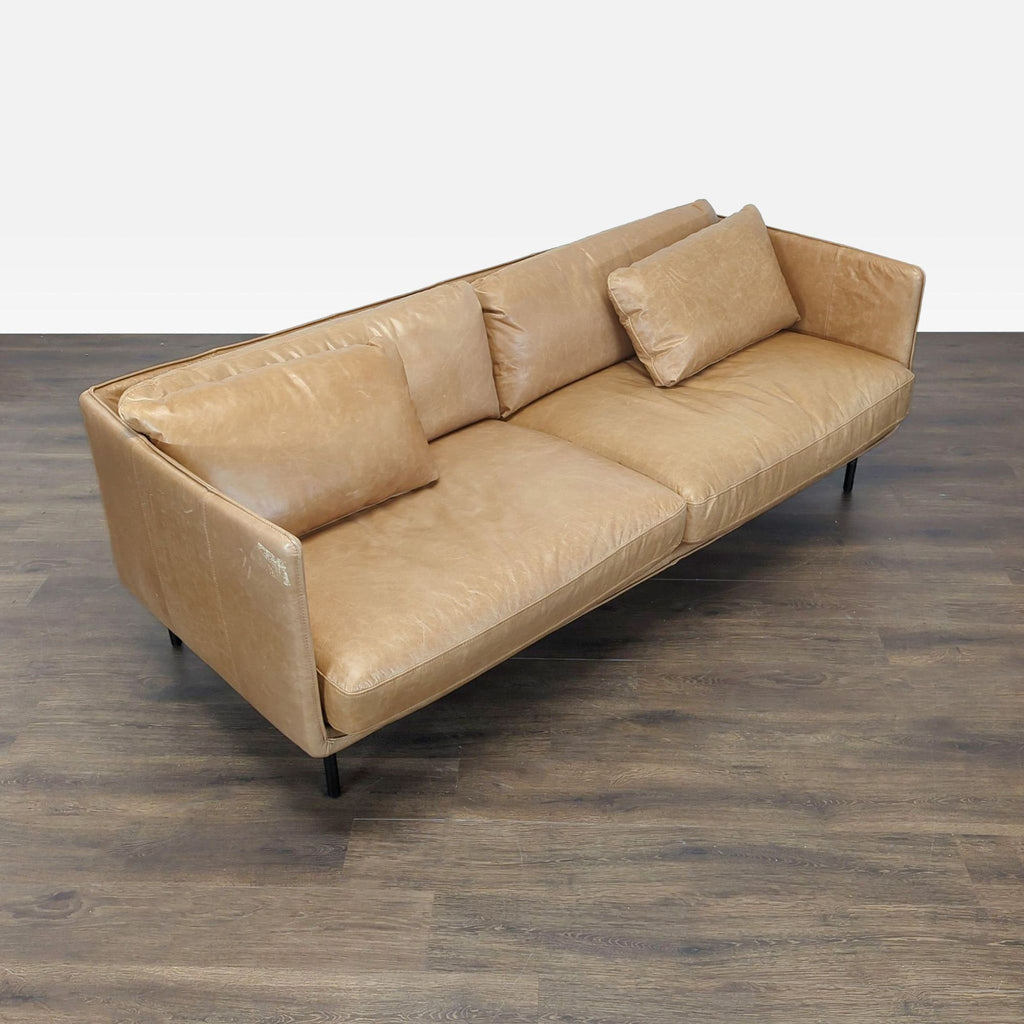 Modern tan leather 3-seater sofa by Crate & Barrel, featuring sturdy black legs and comfortable seating.