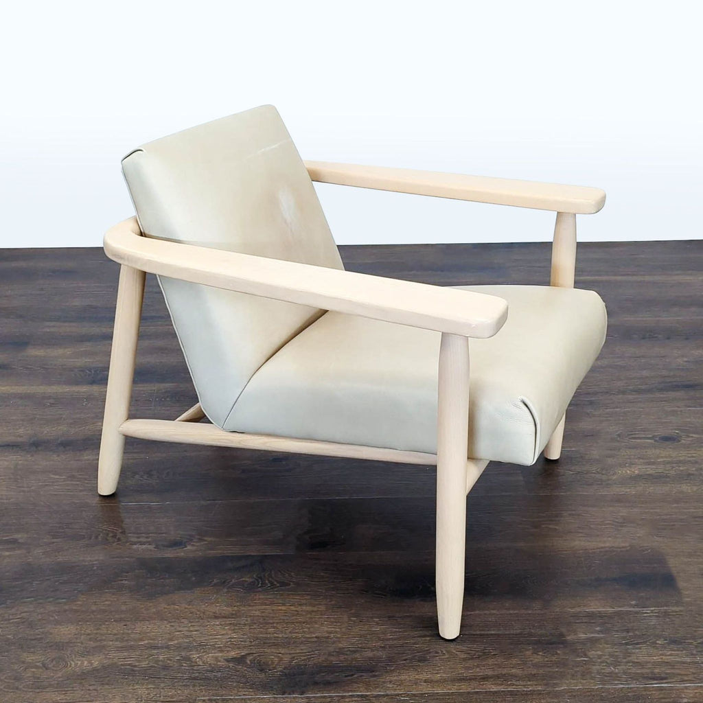 Four Hands lounge chair featuring a wide seat, angled back, and soft cream fabric atop a durable wooden frame.  
