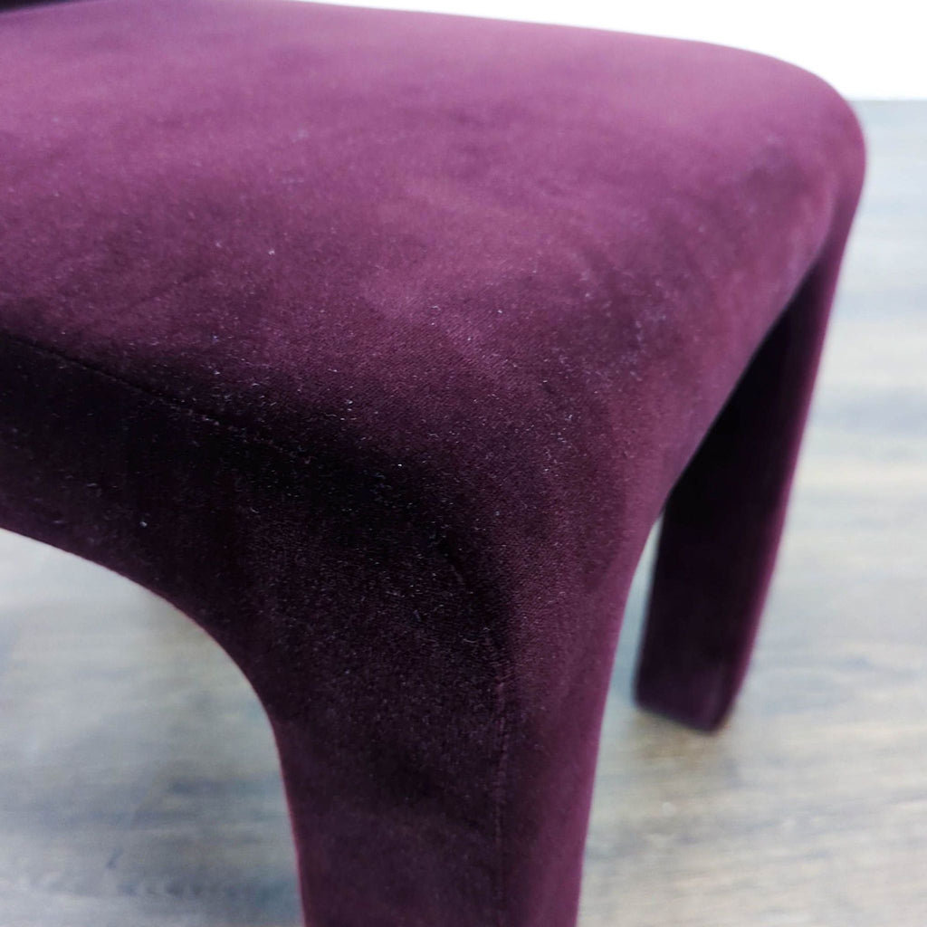 Elegant CB2 dining chair with rich purple velvet and vertical channel tufted details, ideal for dining areas.