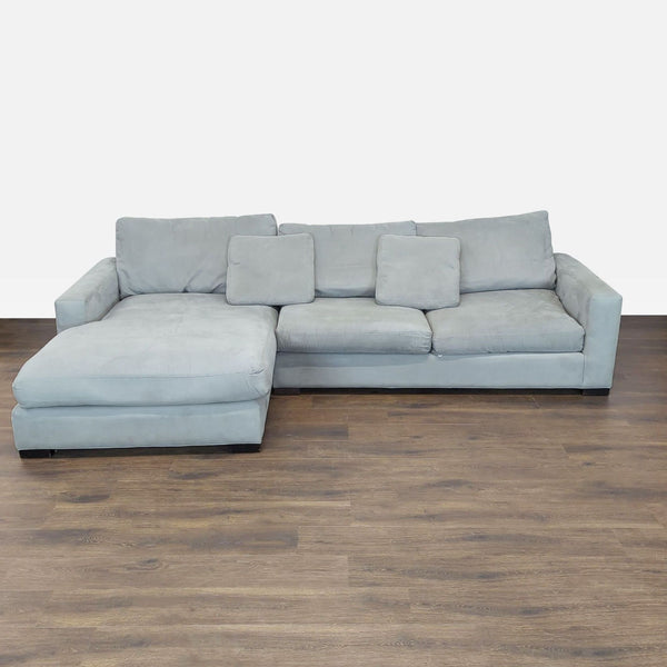 Modern light gray Room and Board sectional with chaise, three back cushions, and two matching accent pillows.