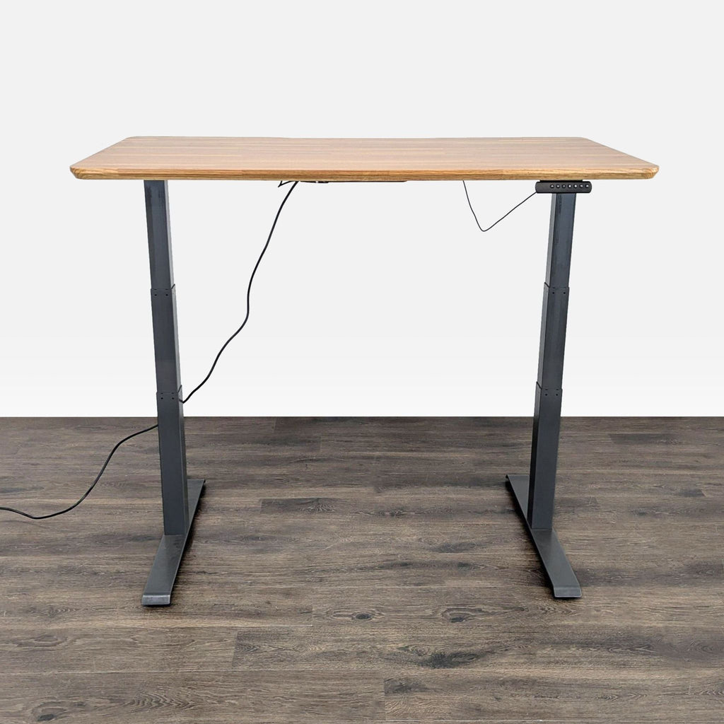 Varidesk sit-stand desk featuring easy controls, sturdy black legs, and a spacious wood-style surface.