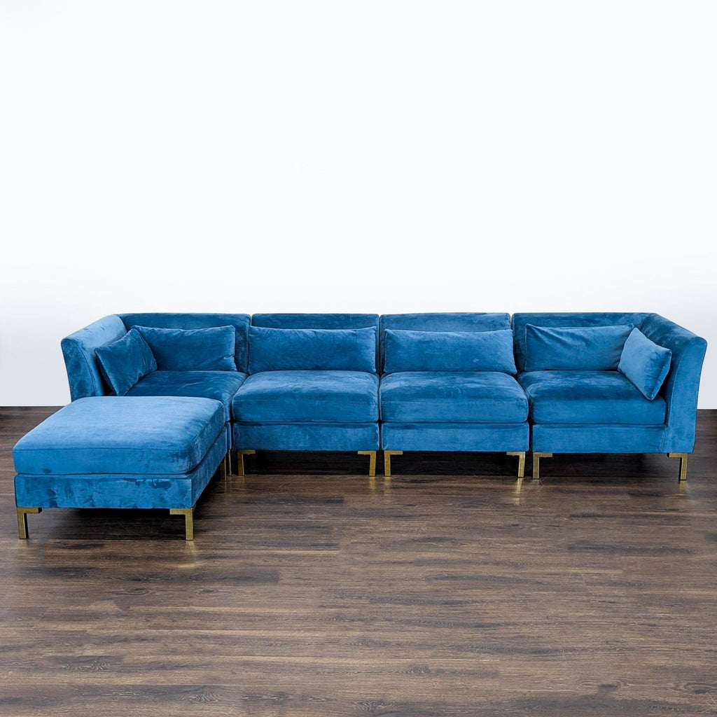1. Modern blue velvet sectional by Chic Home with plush cushions and gold legs, shown from the front.