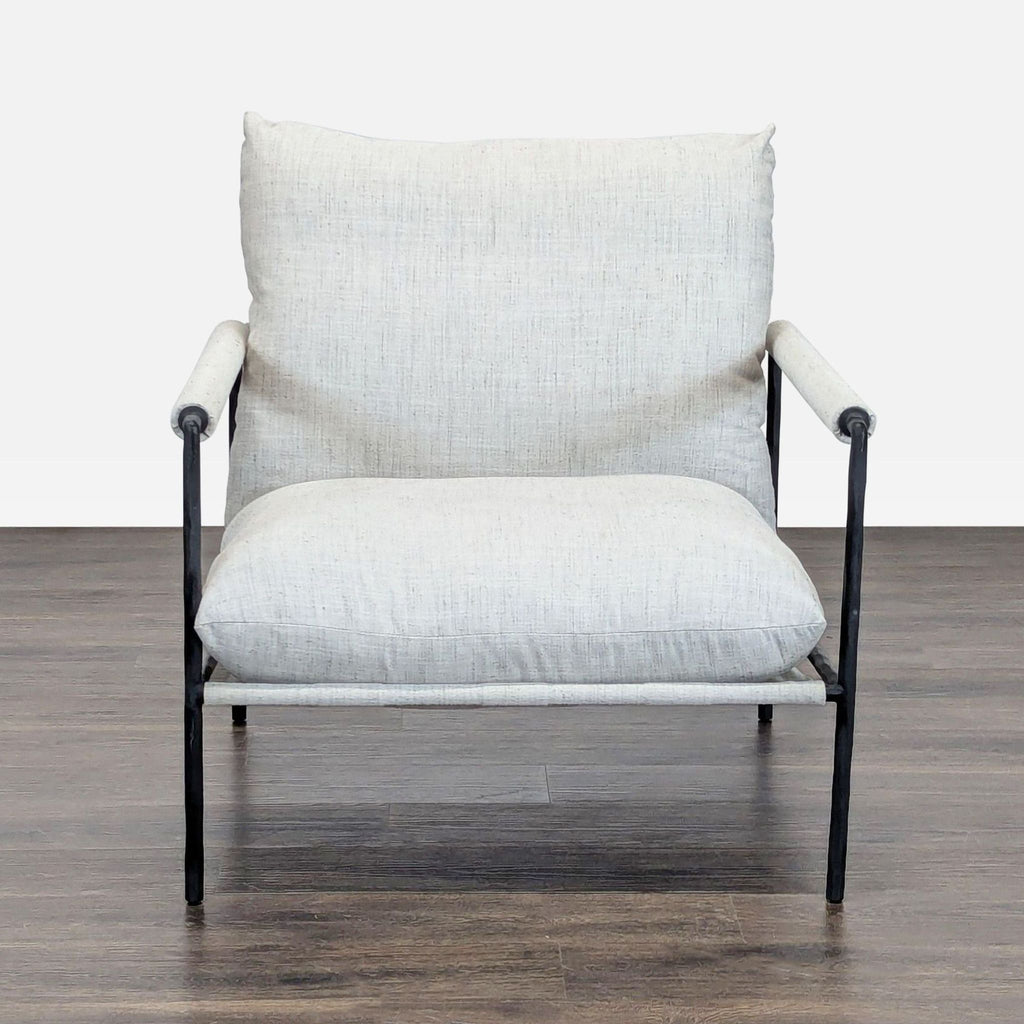 Crate and Barrel chair with a modern black metal frame and light fabric cushions; wide seat, tall backrest.