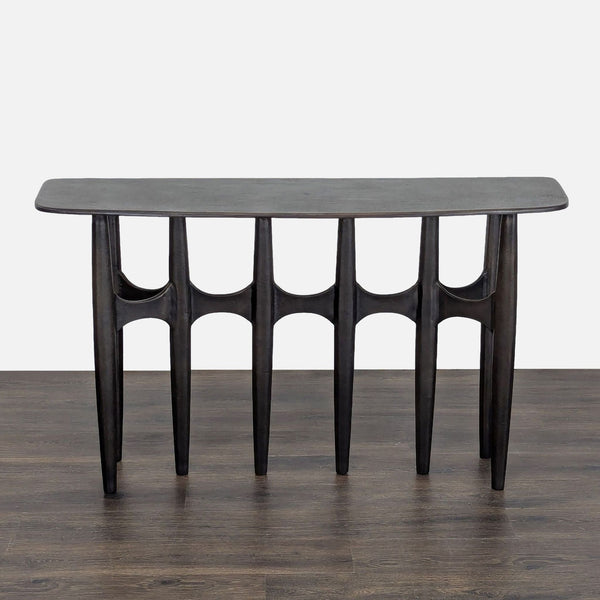 Brutalist-style console table by CB2, featuring textured dark bronze cast aluminum with a curved front.  