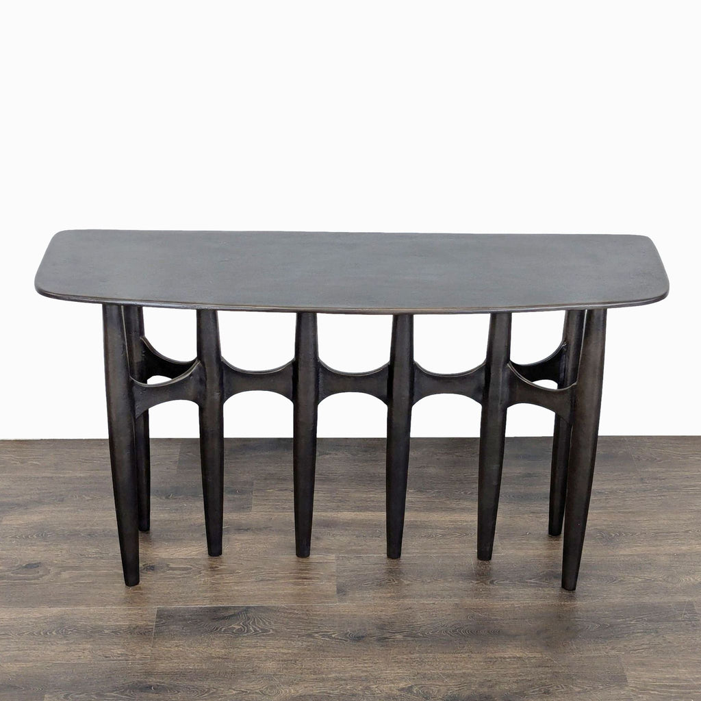 CB2 console table by Amanda Ip, cast aluminum with rugged texture, curved front, flat back for easy styling.