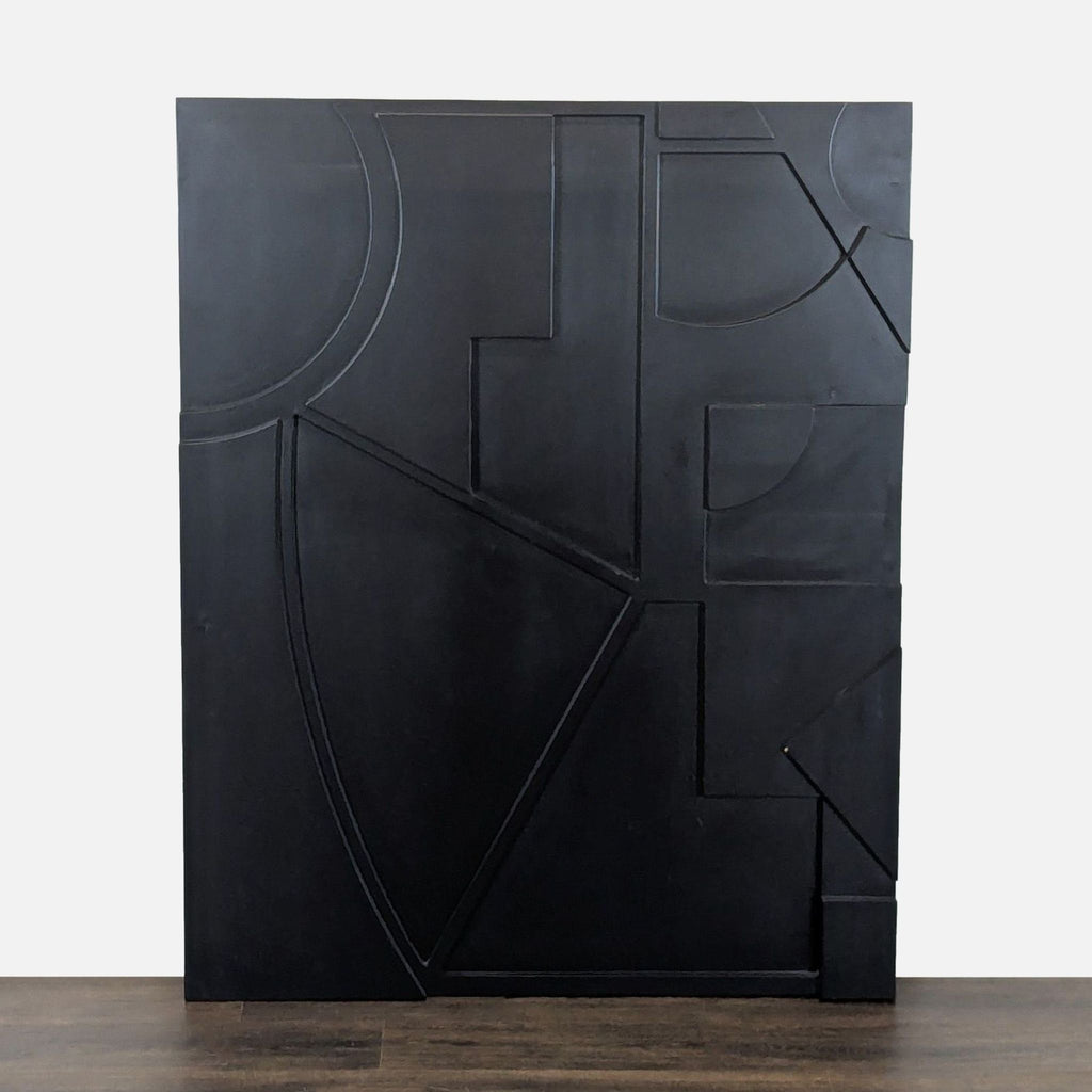 1. Black wall art panel by CB2 featuring raised geometric shapes and lines, displayed upright against a white background.