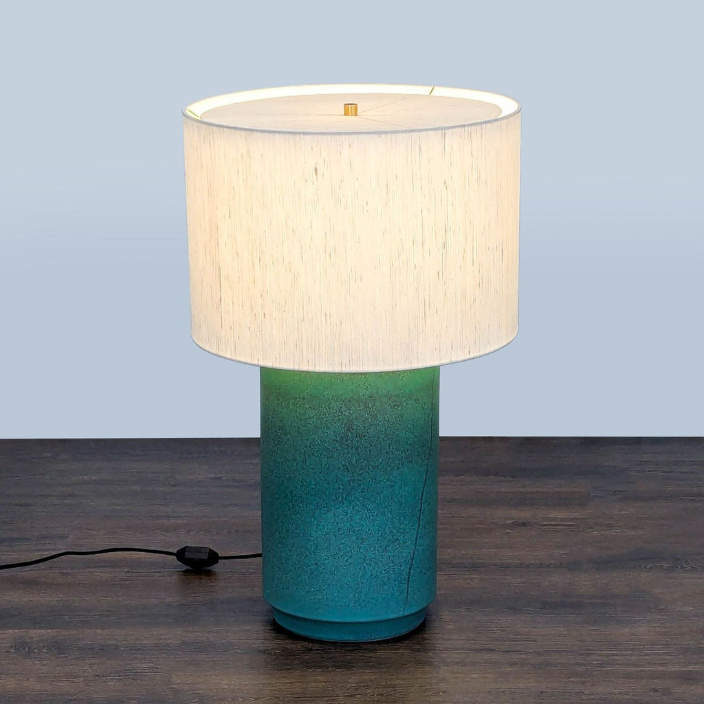CB2 table lamp with green gradient ceramic base and white drum shade, modern design for versatile lighting.