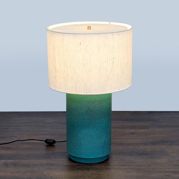 CB2 table lamp with green gradient ceramic base and white drum shade, modern design for versatile lighting.
